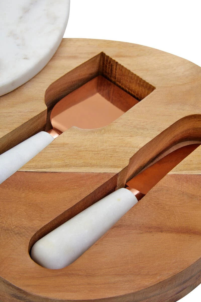 Close-up of the two cheese knives with marble handles and copper-finish blades, stored in the wooden base.