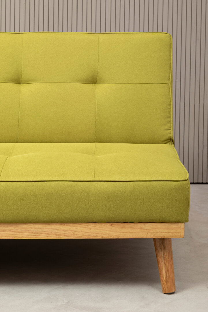 Lime green sofa bed with wooden legs on a neutral background