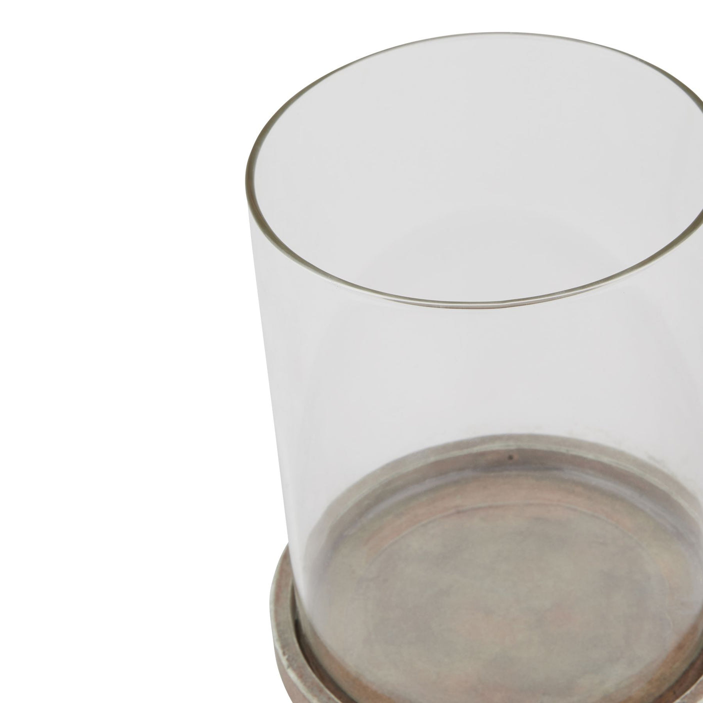 Close up of a glass hurricane lantern with a brown ceramic base