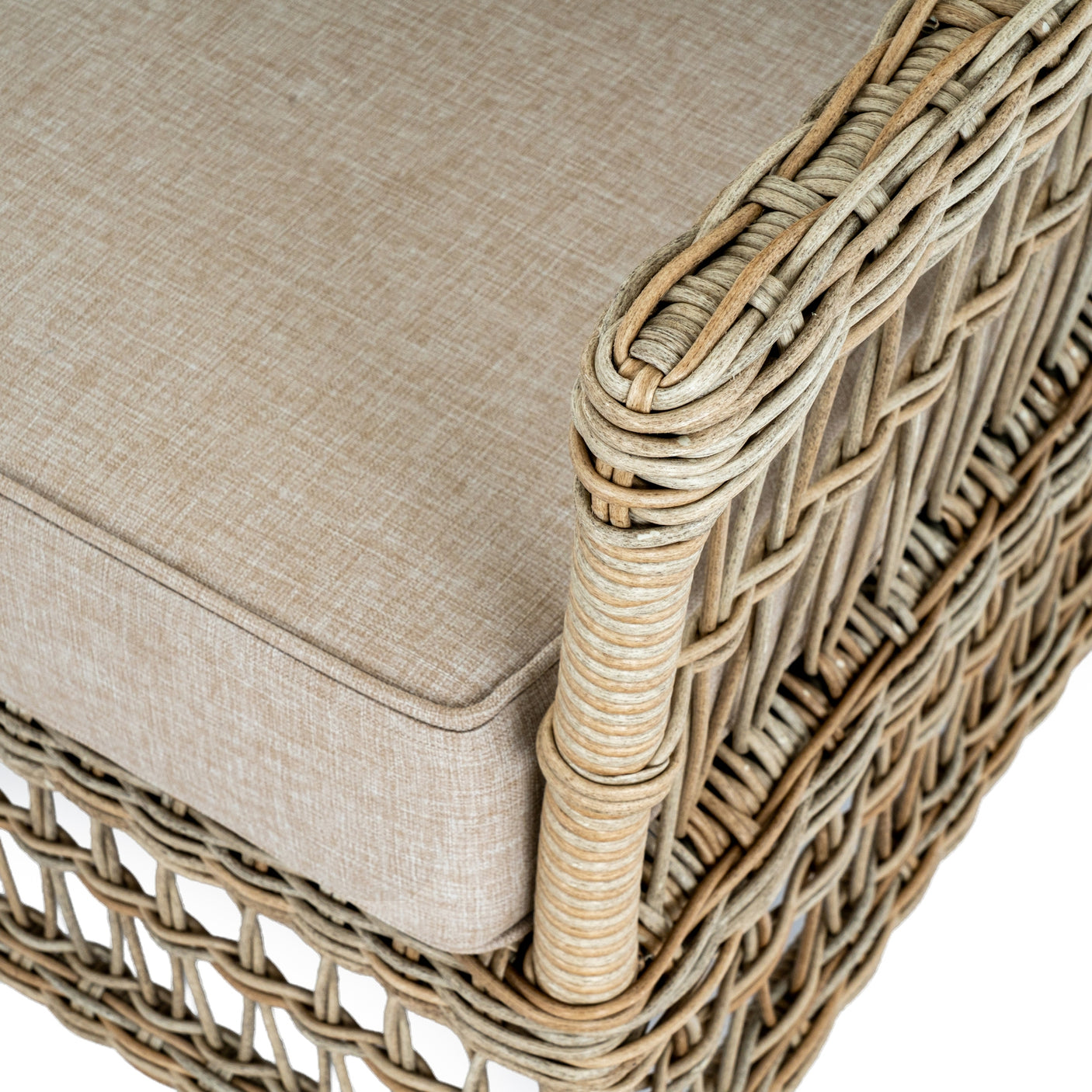 Close-up of a wicker chair with beige cushion on a white background