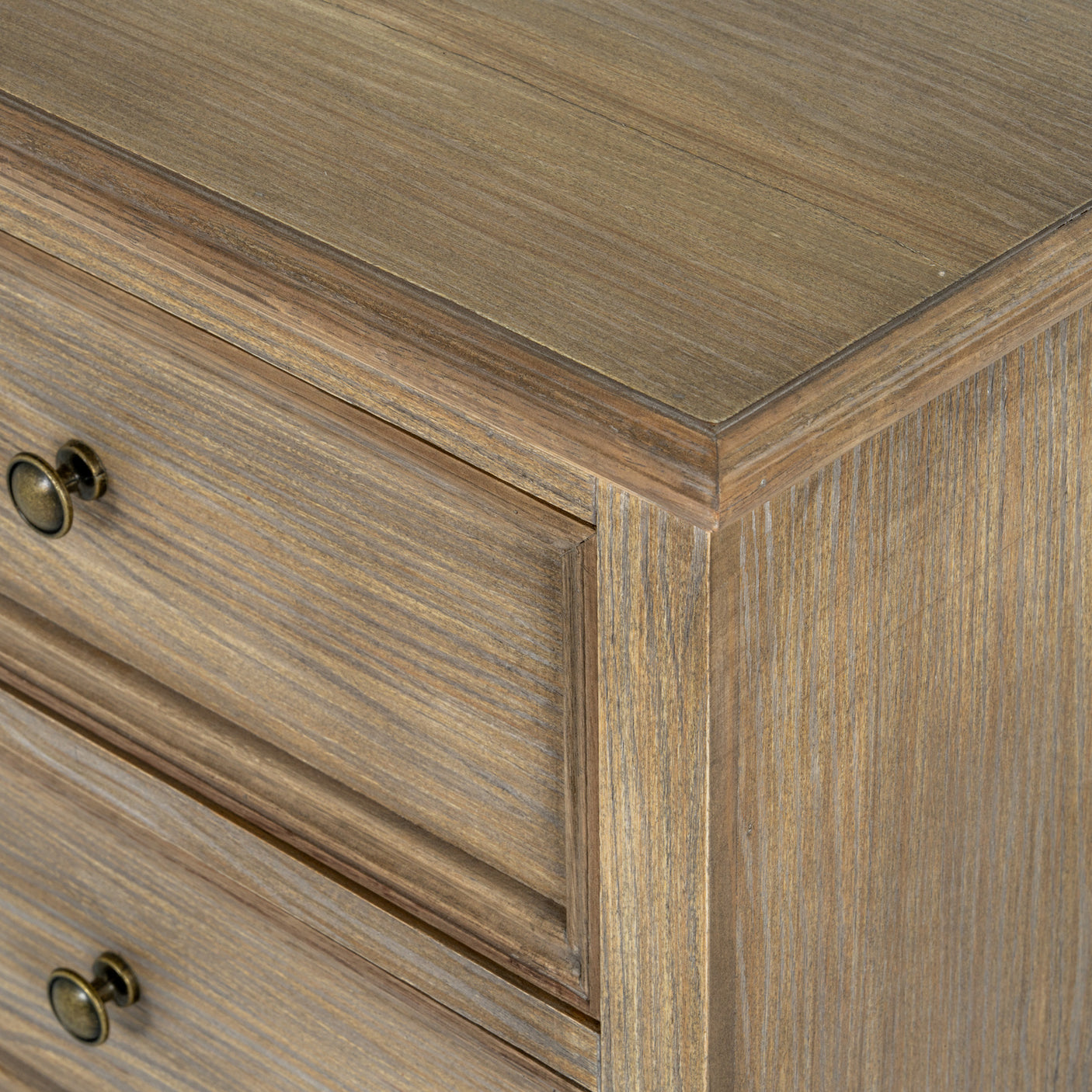 Close-up of a wooden dresser with a focus on the corner and drawers.