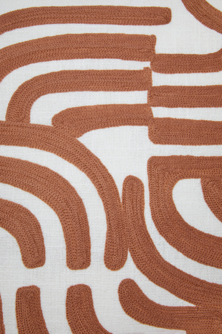 Close-up of the terracotta embroidered curves on the square Elora Natural And Terracotta Cushion