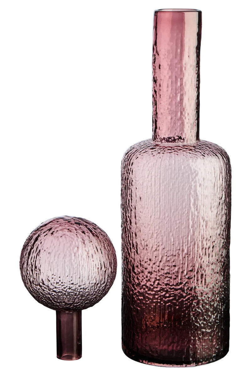 Pink glass bottle and separate spherical stopper on a white background