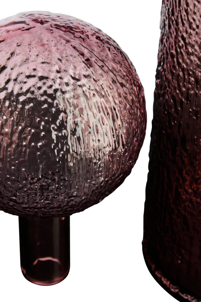 Close-up of a textured pink vase and stopper on a white background
