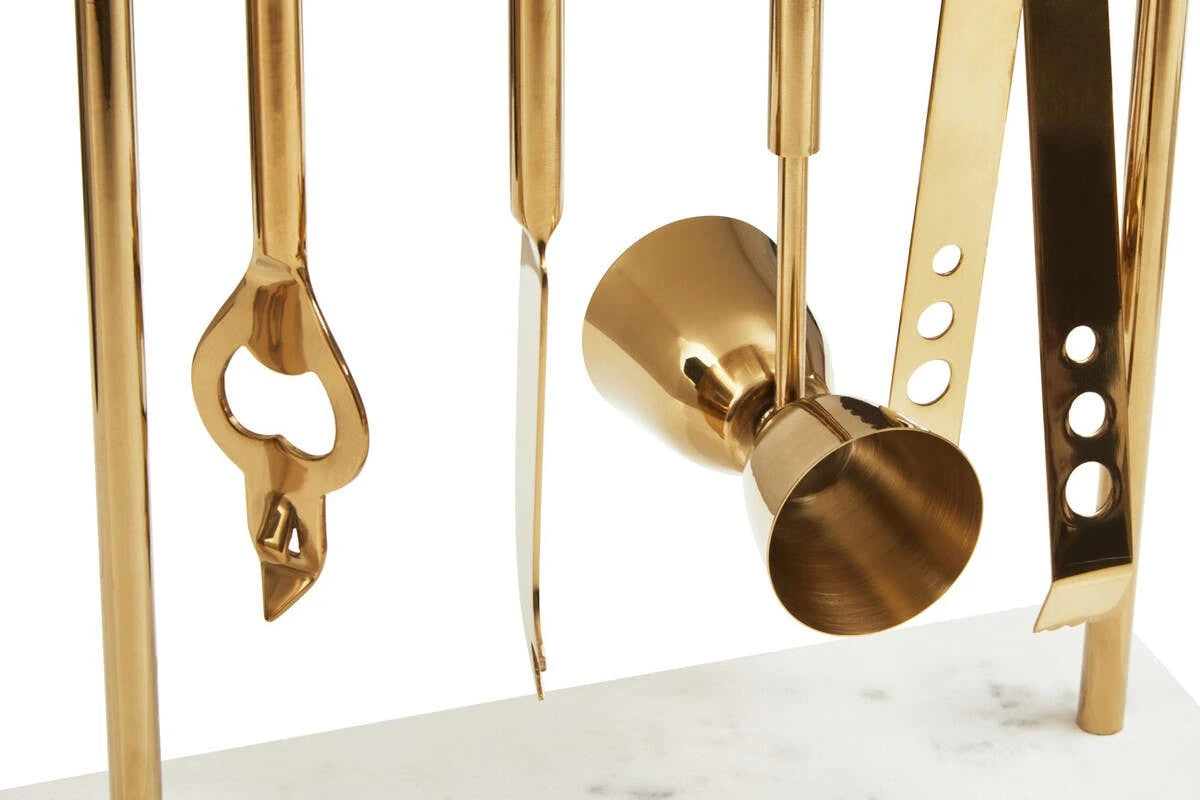 Close-up of the gold-finish bottle opener, knife, jigger and tongs