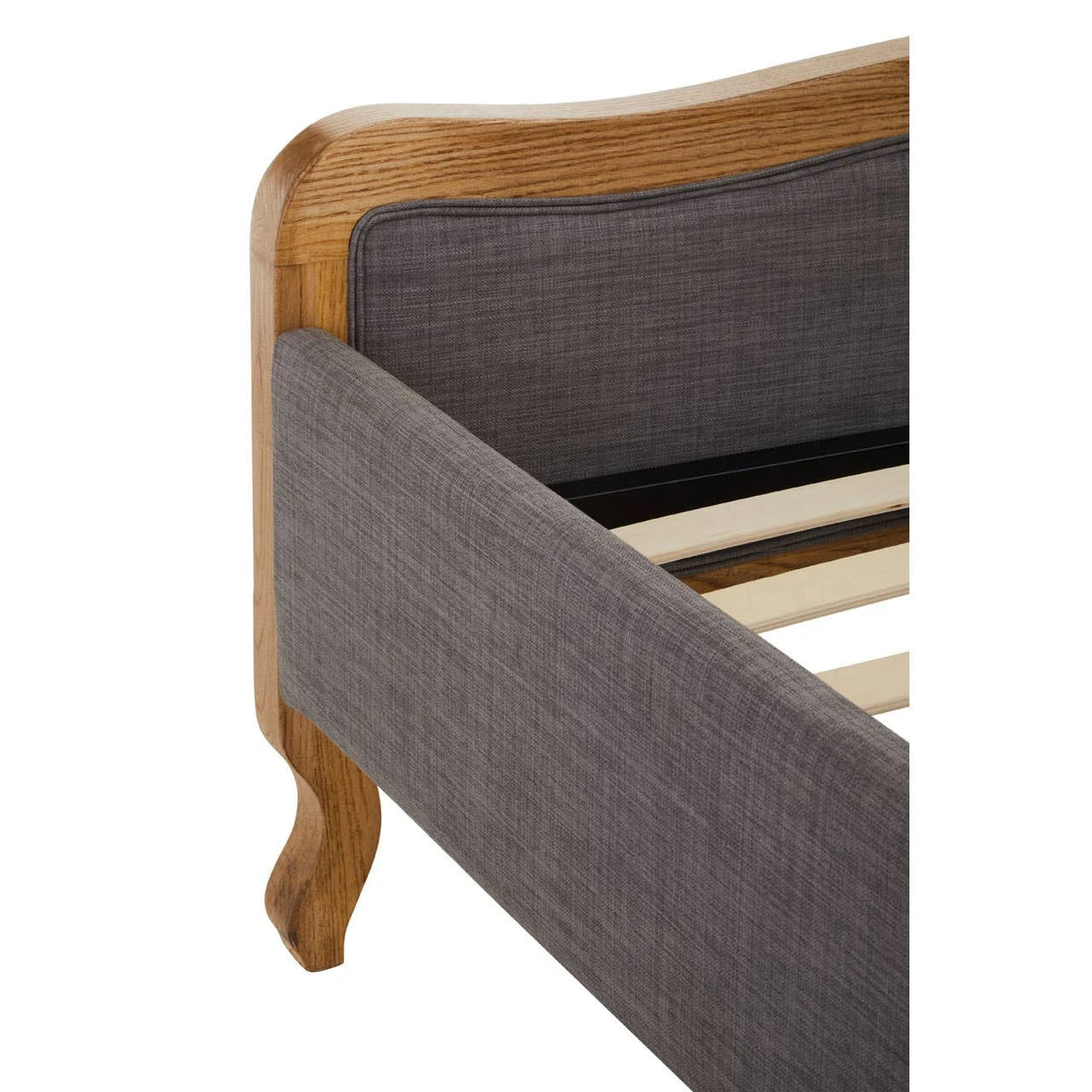 Close view of the Vienne bed footboard corner, showing the shaped oak frame, grey upholstered rail and cabriole leg.