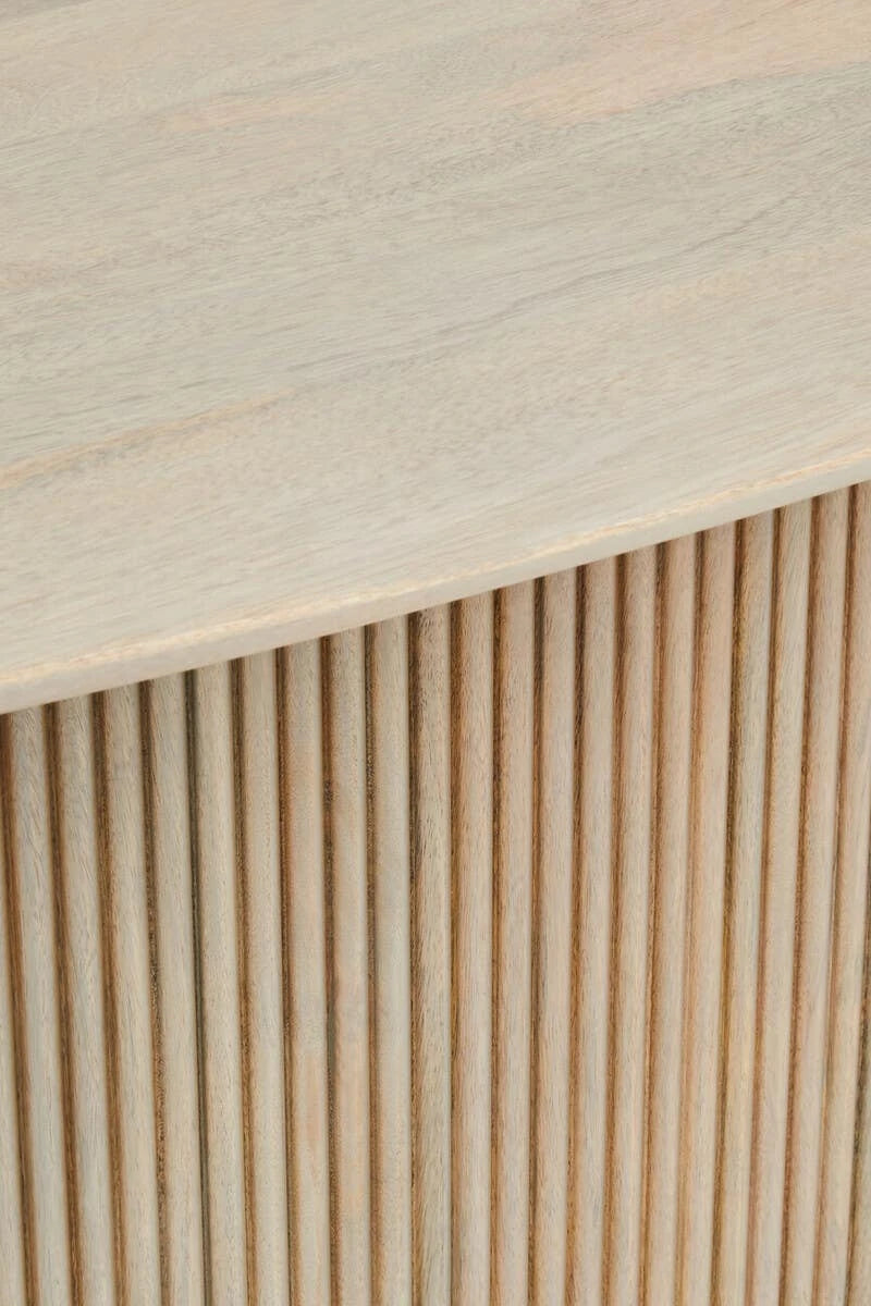 Close-up of the curved edge of the Hawthorn Grey dining table top above the fluted mango wood base.