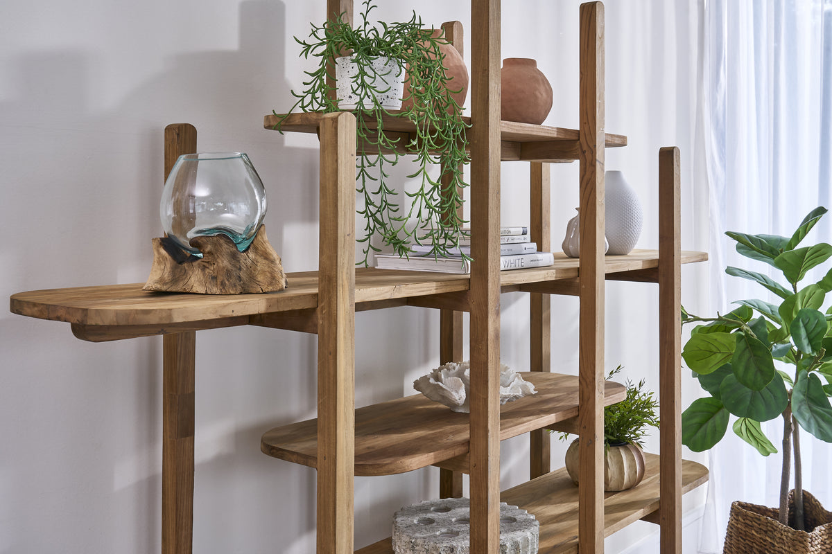 Wooden shelf with decorative items and plants against a white wall
