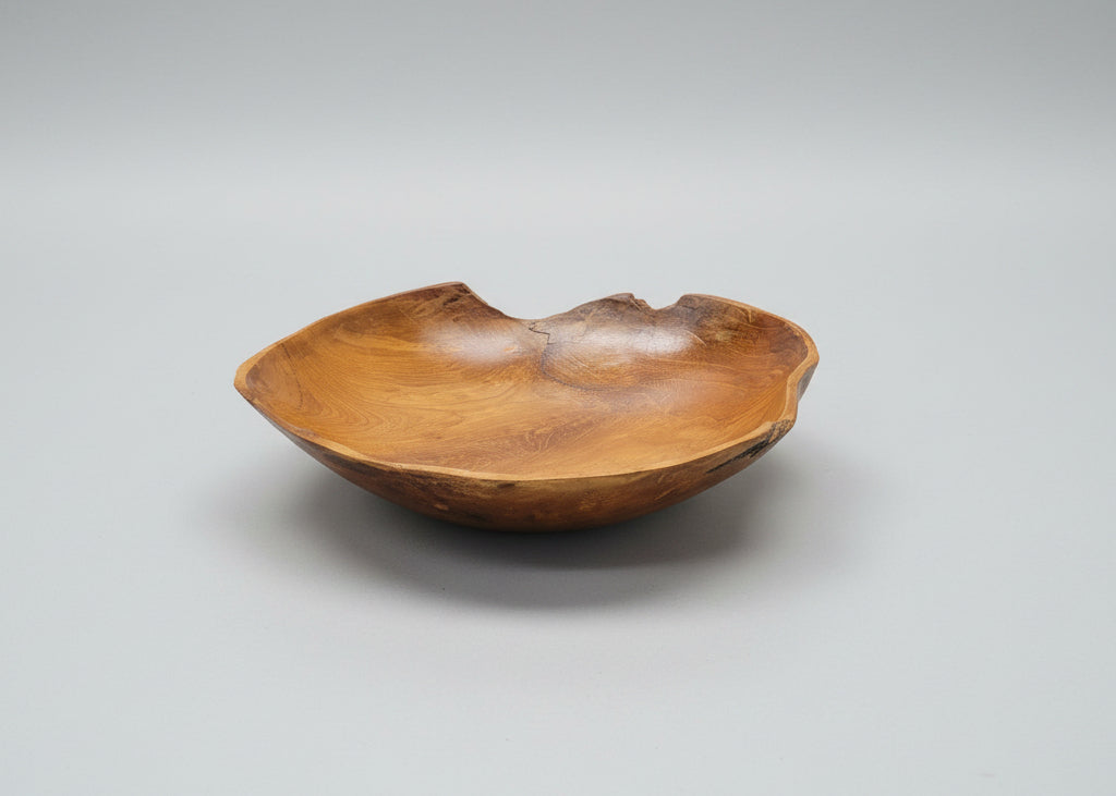 Teak root wooden bowl on a grey background