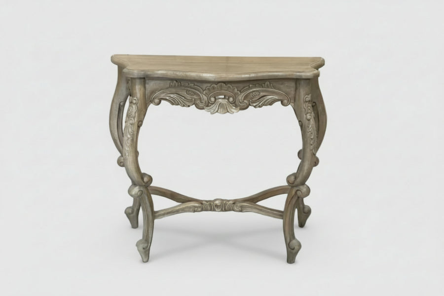 An ornate console table with a distressed gray wood finish, featuring carved details on the apron and legs, set against a plain light gray background.