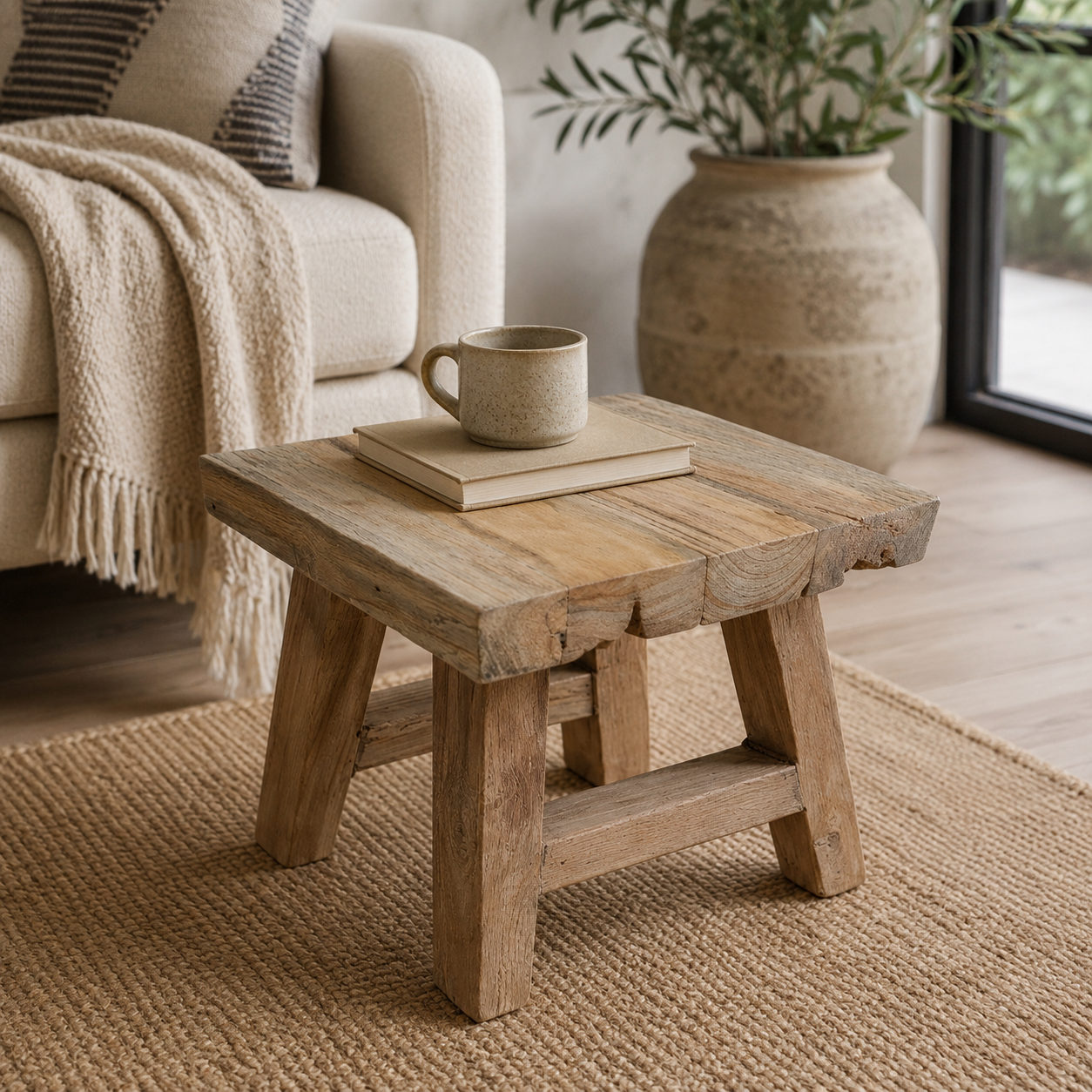 Wooden side table with a cup and book in a cozy living room setting.