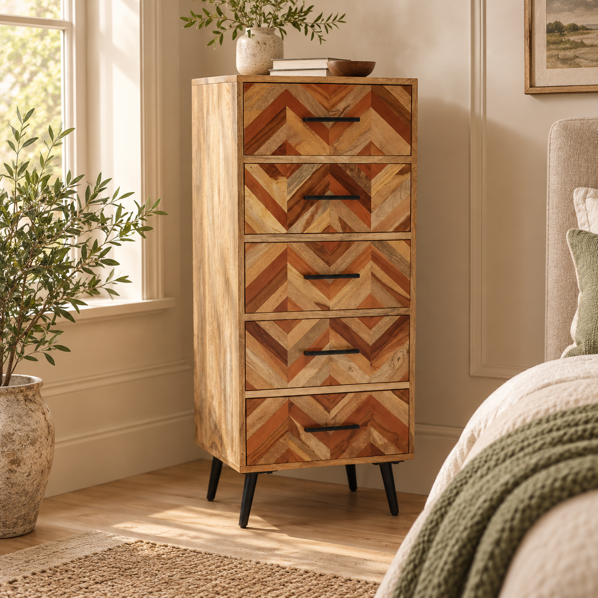 Tessera 5 Drawer Mango Wood Chest of Drawers in a bedroom by a window, styled with an olive tree, a vase of greenery and a framed print