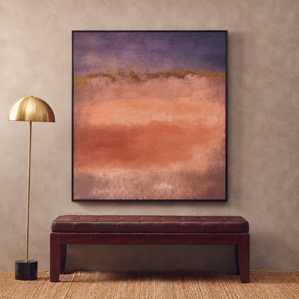 Abstract painting on a wall above a brown leather bench with a gold floor lamp to the left.