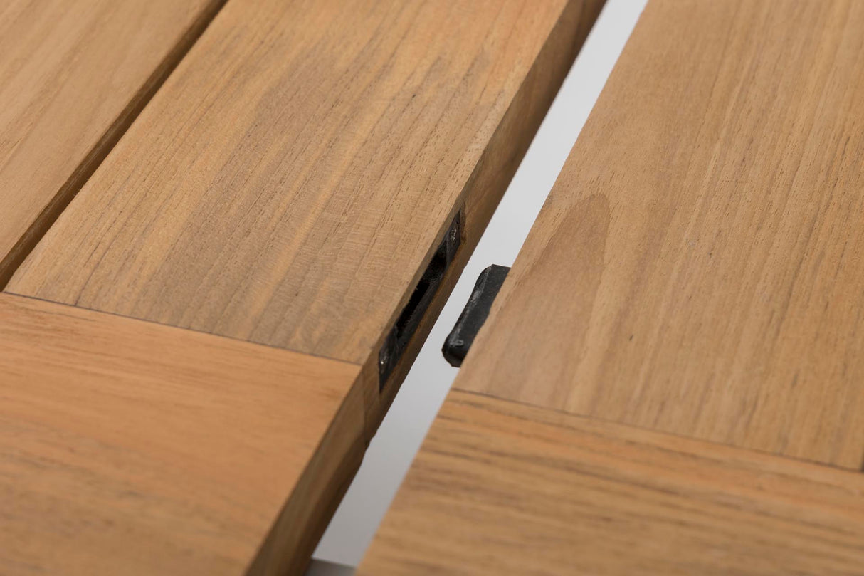 Close-up of a light oak wood table or bench with a visible black metal hinge or latch mechanism between the slats.