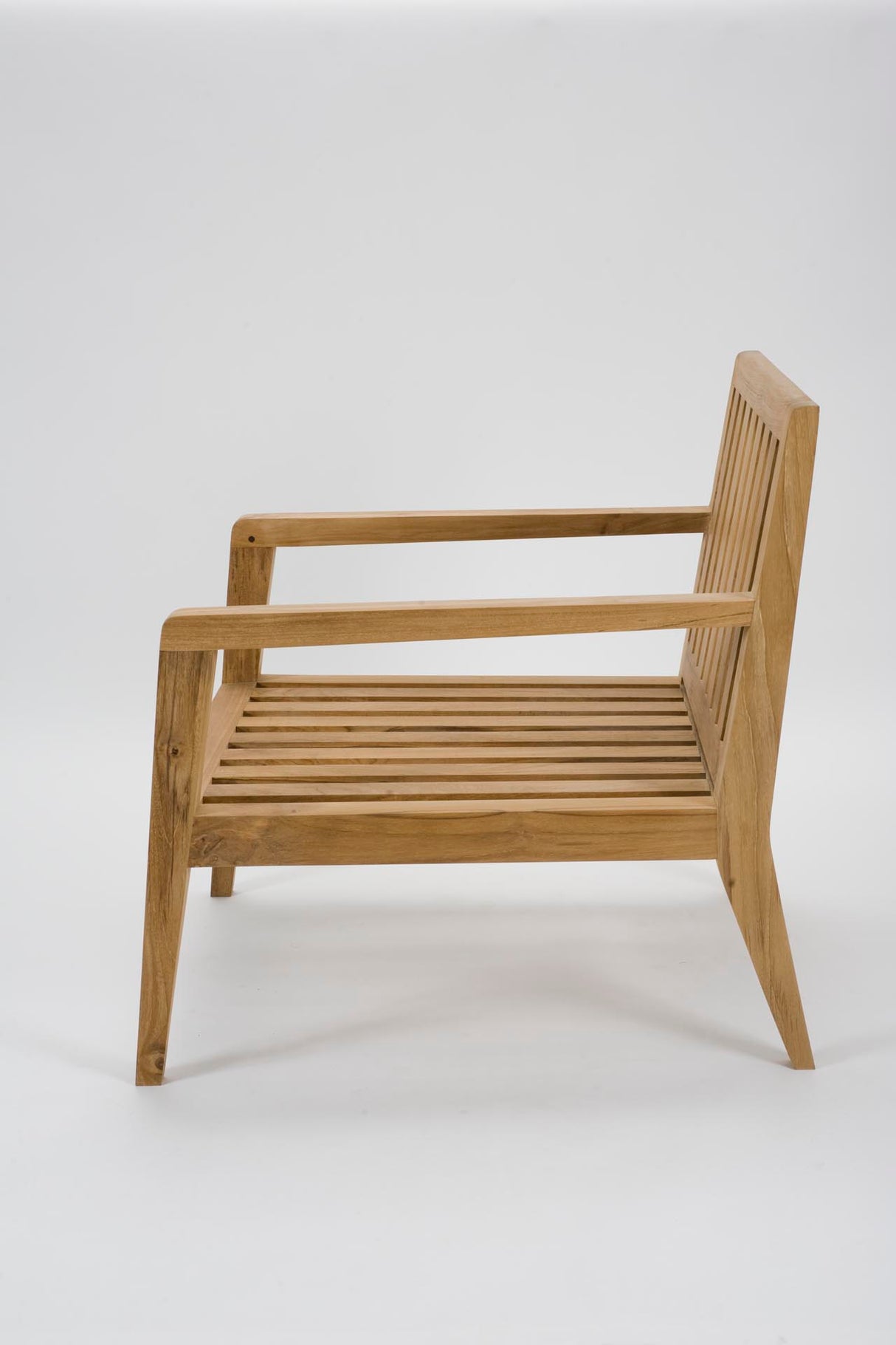 A mid-century modern wooden armchair with a slatted seat and backrest, shown from a side angle against a plain white studio background.