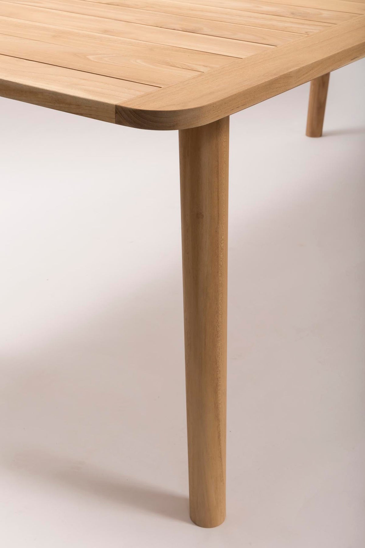 Close up of Shoreditch teak wood outdoor dining table on a white background