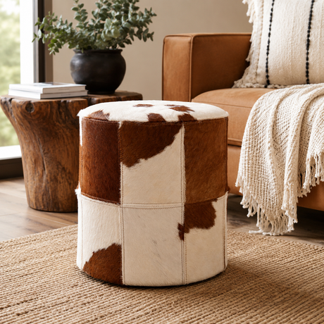 Round ottoman with cowhide pattern in a living room setting