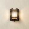 Wall-mounted outdoor light fixture with glass cover on a neutral wall.