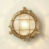 Round metallic wall light fixture with grid design on a white wall.