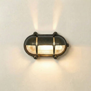 Wall-mounted light fixture with glass cover on a neutral background