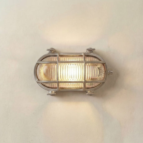 Wall-mounted light fixture with glass cover on a white wall
