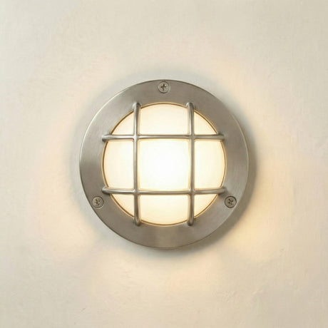 Round wall light fixture with grid design on a white wall