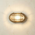 Brass wall light fixture on a textured white wall