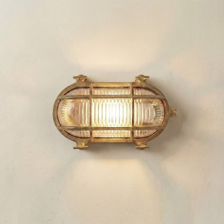 Horatio junior bulkhead outdoor wall light in raw brass on a neutral wall