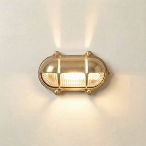 Gold wall light fixture on a white wall