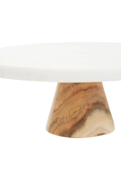 Close-up of the swirling grain of the acacia wood pedestal beneath the marble top of the Loxley Cake Stand.