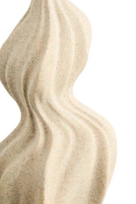Close up of a beige wavy textured vase on a white background