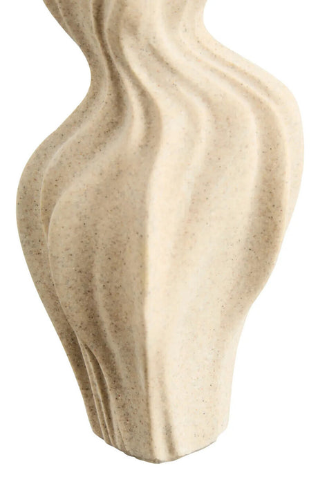 Close up of a wavy textured beige vase on a white background