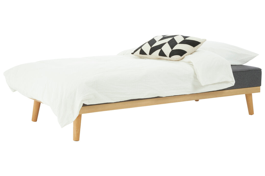 Bed with white bedding and a black and white patterned pillow on a white background