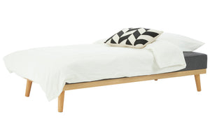 Bed with white bedding and a black and white patterned pillow on a white background