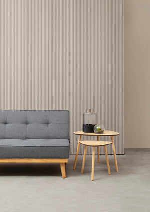 Skagen grey fabric sofa bed with a neutral background and styled with a set of two side tables