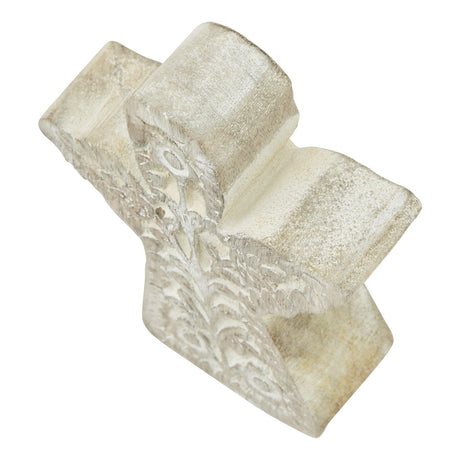 Angled view of the whitewashed carved wooden angel showing its floral carving