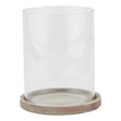 Clear glass candle holder with a concrete base on a white background