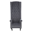 Gray tufted chair with high back and armrests on a white background