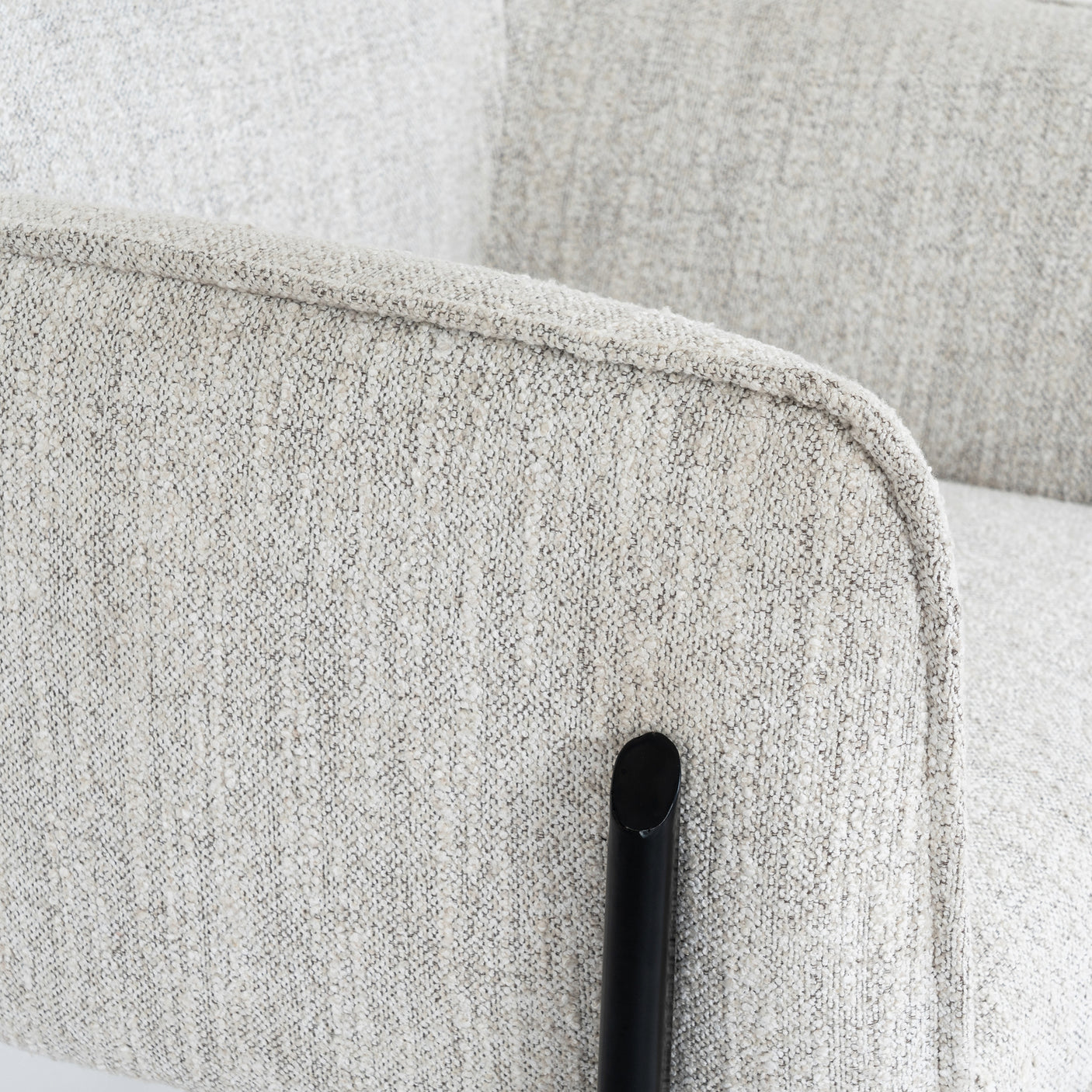 Close-up of a textured gray fabric chair with a black frame.