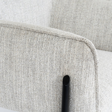 Close-up of a textured gray fabric chair with a black frame.
