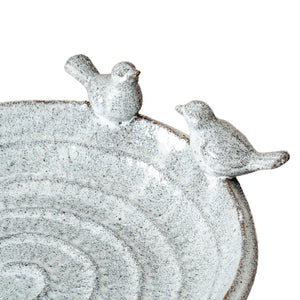 Ceramic bird bath with two bird figures on a white background