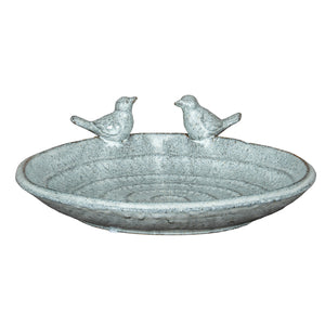 Decorative stone bird bath with two small bird figurines on a white background