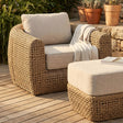 Wicker outdoor furniture set with beige cushions on a wooden deck.