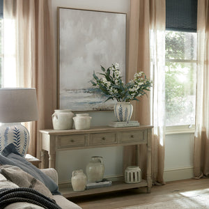 Living room with a wooden console table, decorative vases, and a painting on the wall.