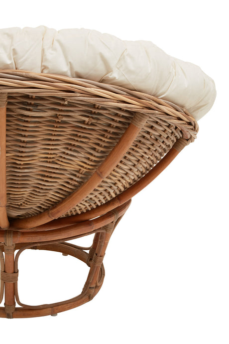 Wicker chair with a cream cushion on a white background