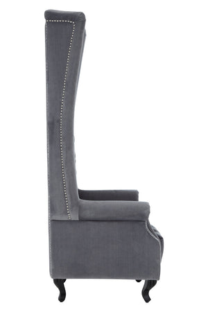 Side view of grey tufted chair with high back and armrests on a white background