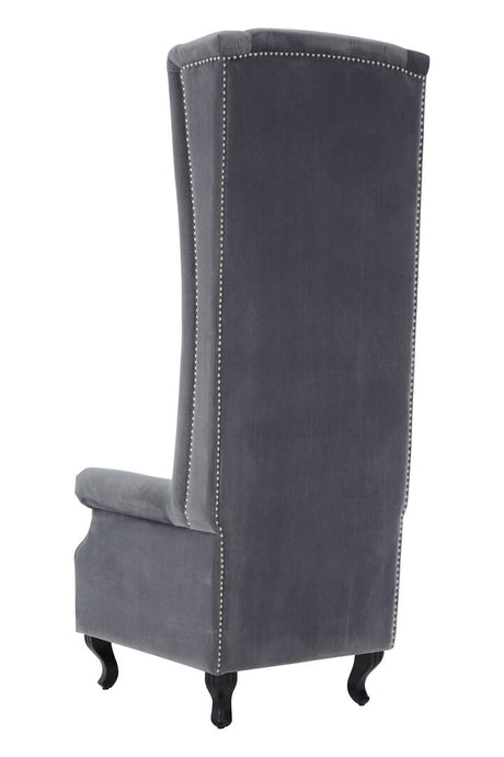 Back corner view of a grey tufted chair with high back and armrests on a white background