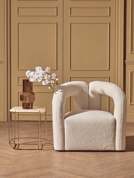 Beige armchair in a room with a wooden floor and beige walls.