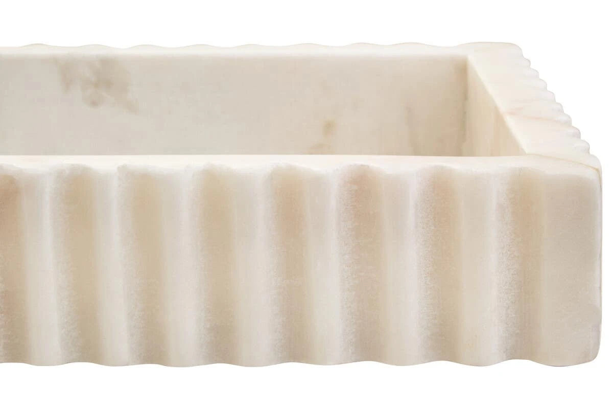 Close view of the fluted marble edge of the Vela tray, showing its carved, tactile texture.