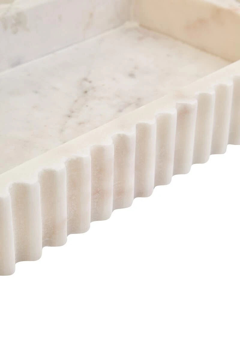Close-up of the Vela white marble tray from above, showing the veined base and fluted outer wall.
